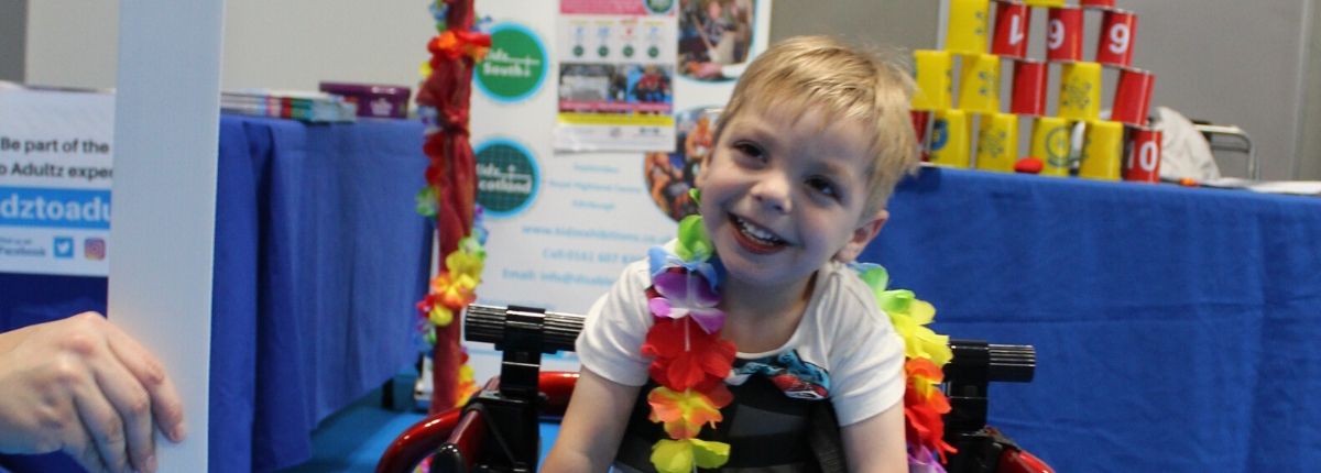 young boy smiling with hawaiian flowers around his neck