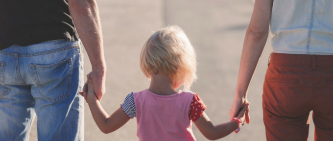 little girl holding her parents hands