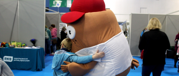 child giving mascot a hug