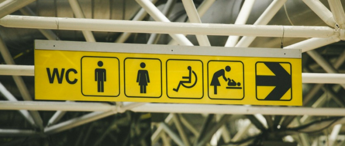 public toilets sign with icons and arrow