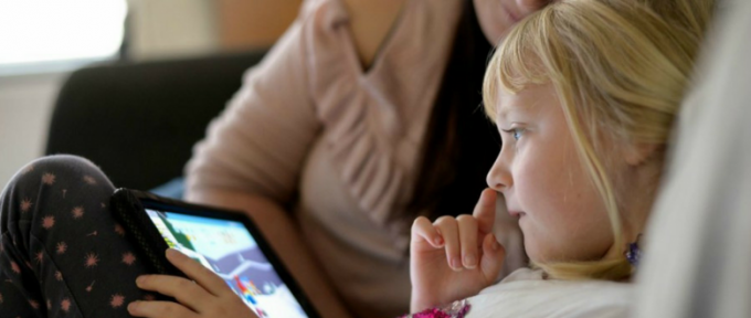 little girl looking at tablet