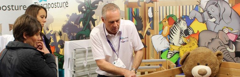 theraposture representative showing visitors a piece of equipment