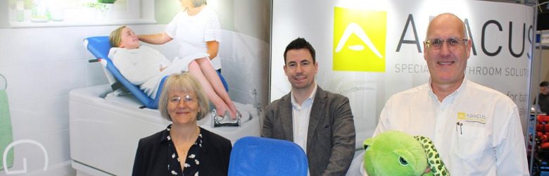 three abacus representatives stood at their exhibition stand