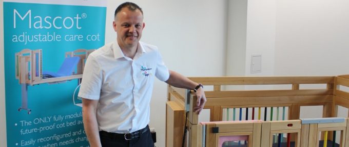 shaun stood by care cot at Theraposture stand