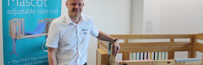 shaun stood by care cot at Theraposture stand