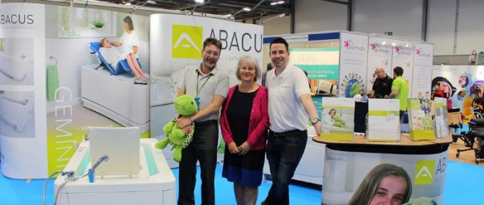 kate with two abacus colleagues stood at their stand