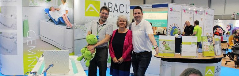 kate with two abacus colleagues stood at their stand