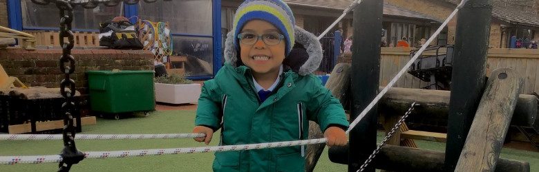 young boy smiling in adventure playground