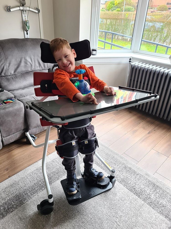 young boy using postural management equipment