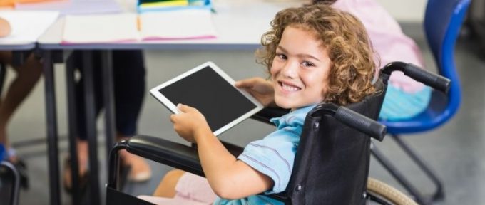 young boy in wheelchair using tablet