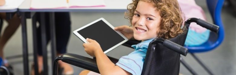 young boy in wheelchair using tablet