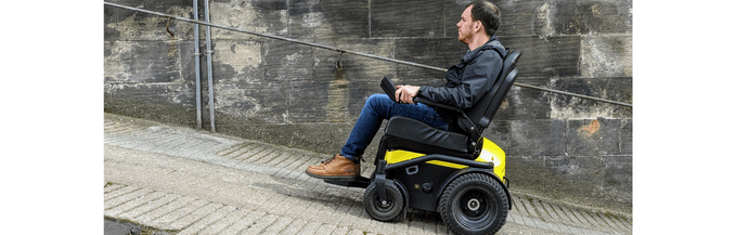 image of man in power wheelchair going up hill