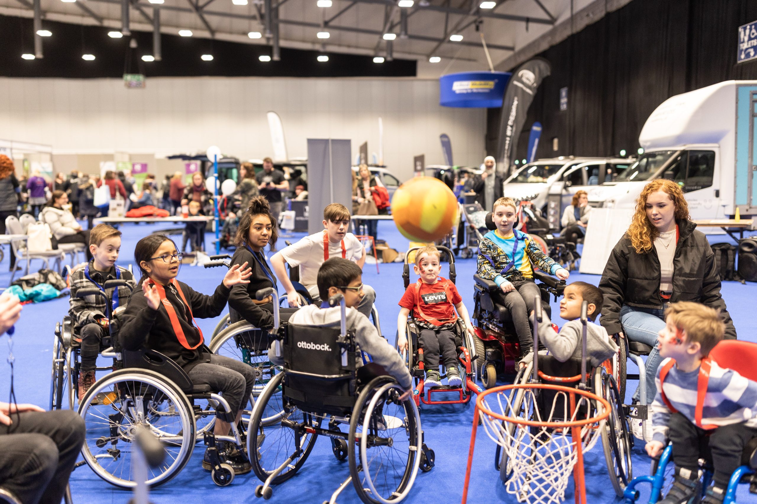 Girls and boys playing basket ball in wheel chairs