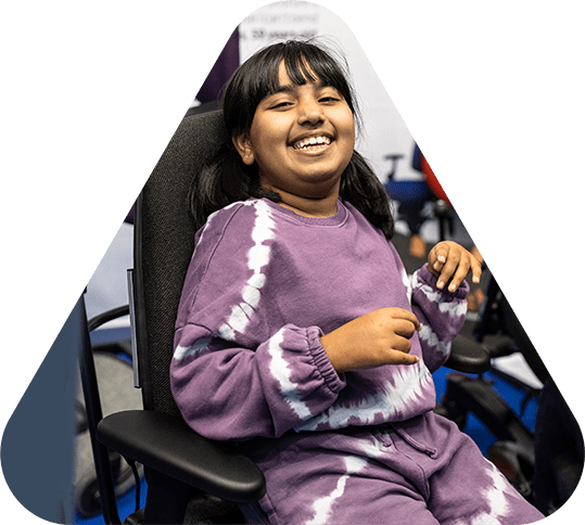 Smiling girl sat in wheelchair at Kidz to Adultz event