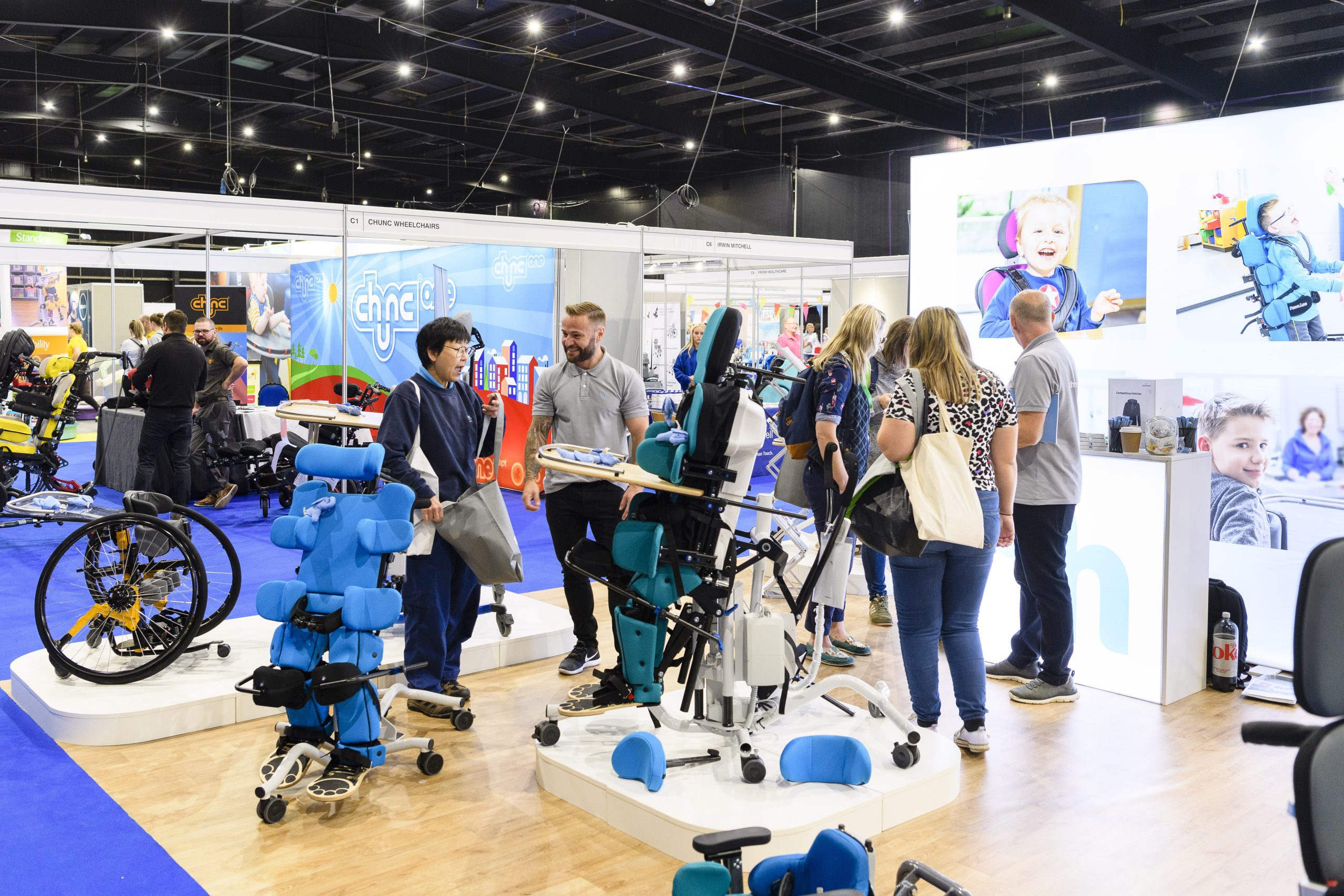 Busy exhibition stand with attendees testing equipment