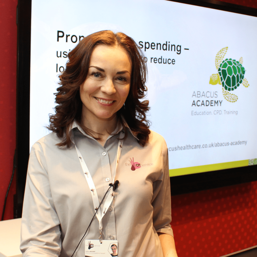 Lucy stood at the front of a seminar smiling at the camera