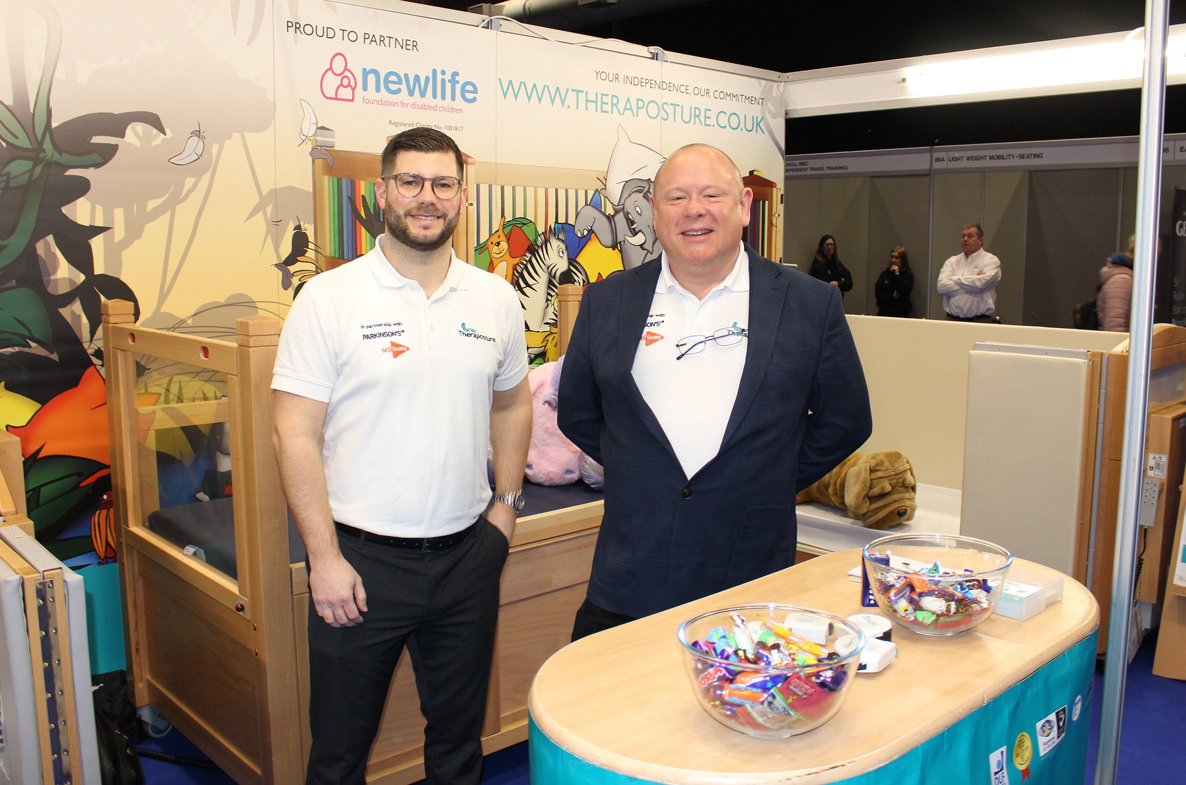 Two members of the Theraposture team smiling behind their stand